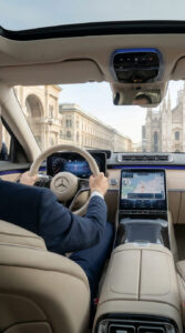 Vista dall'interno di una Mercedes-Benz Classe S con conducente mentre guida verso il Duomo di Milano